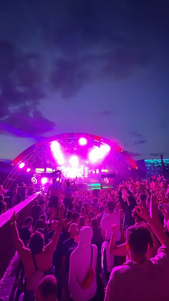 Público mirando al escenario en la noche del Spring Break Island, junto al humo y los láseres