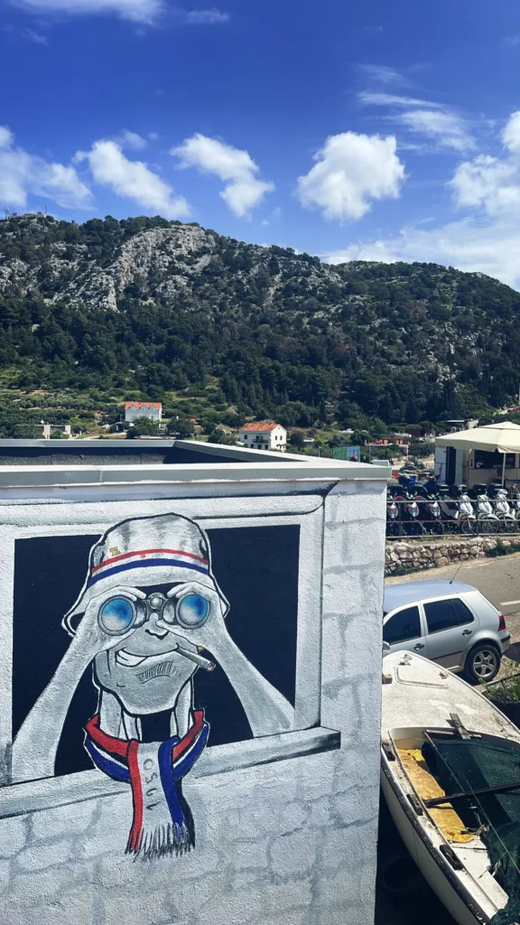 Graffiti de hincha con gorro pesquero y prismáticos, bufanda del Hajduk y la leyenda "1950", año de fundación de Torcida Split