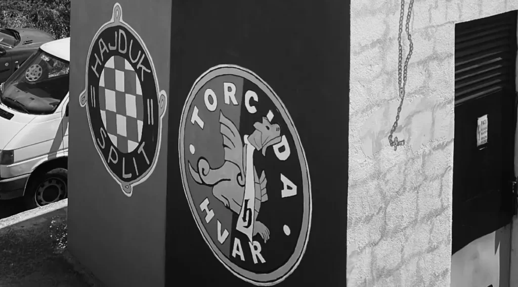 Graffiti "Torcida Hvar" junto al escudo del Hajduk Split en versión blanco y negro